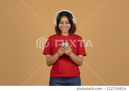 Happy young arabic woman watching podcast on smartphone Happy young arabic woman watching podcast on smartphone 112724814
