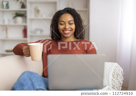 Home Pastime. Young Black Woman Resting With Coffee And Laptop Computer Home Pastime. Young Black Woman Resting With Coffee And Laptop Computer 112724910