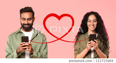 A man with a beard in an olive shirt smiles at his smartphone, and a woman with curly hair A man with a beard in an olive shirt smiles at his smartphone, and a woman with curly hair 112725069