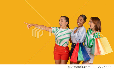 Amazed multiracial girlfriends shopaholics looking at copy space Amazed multiracial girlfriends shopaholics looking at copy space 112725488