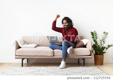 Emotional young indian man looking at laptop and gesturing 112725550