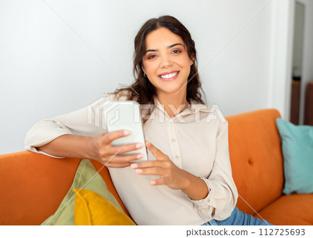 Portrait Of Beautiful Cheerful Millennial Woman Using Mobile Phone At Home 112725693