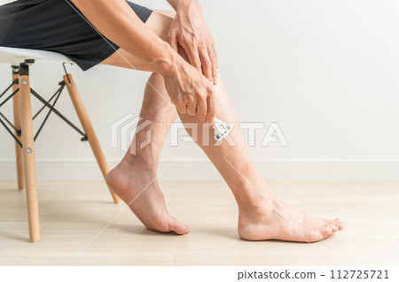Men removing unwanted leg hair, hair removal, shaving, shaving, self-treatment, home care 112725721