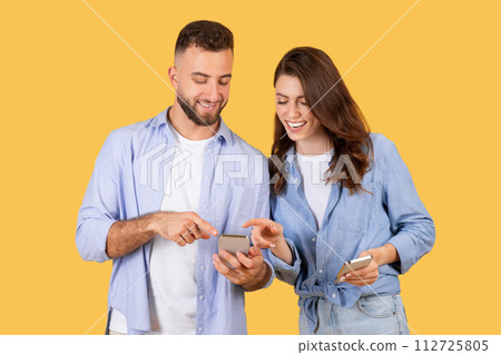 Happy young couple sharing content on smartphones 112725805