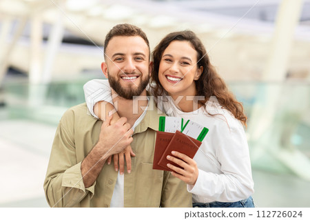 Portrait Of Joyful Young Couple With Passports And Tickets Posing At Airport 112726024