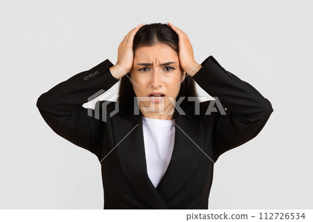 Stressed businesswoman with hands on head, showing frustration Stressed businesswoman with hands on head, showing frustration 112726534