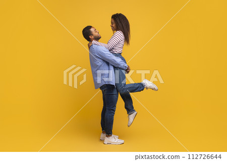 Side view of romantic young black man holding and hugging his girlfriend Side view of romantic young black man holding and hugging his girlfriend 112726644