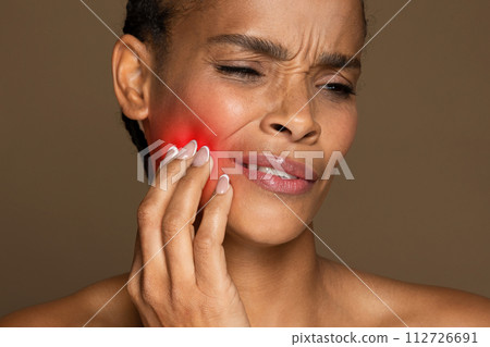 African american woman with red spot on cheek indicating pain 112726691