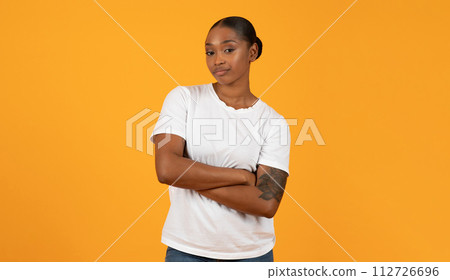 black woman poses with crossed arms displaying displeased expression, studio 112726696