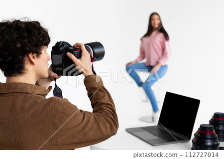 Photographer focusing on woman during photo session Photographer focusing on woman during photo session 112727014