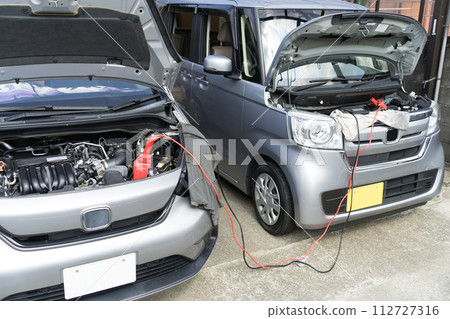 Car battery run-up and first aid Jumping start with booster cable Car battery run-up and first aid Jumping start with booster cable 112727316