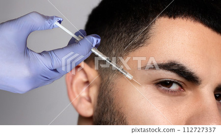 Handsome bearded man visiting aesthetic clinic, getting anti-aging treatment 112727337