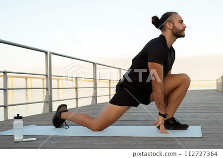 man flexing legs in kneeling hip flexor stretch exercising outdoors man flexing legs in kneeling hip flexor stretch exercising outdoors 112727364