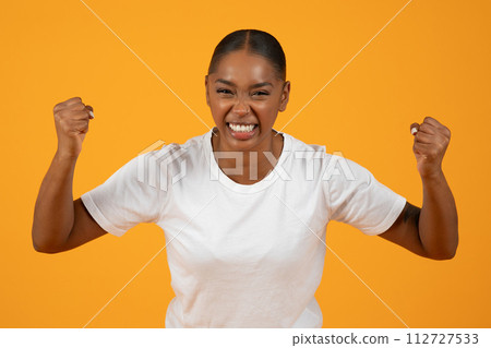 African American lady clenches fists in anger and effort, studio 112727533