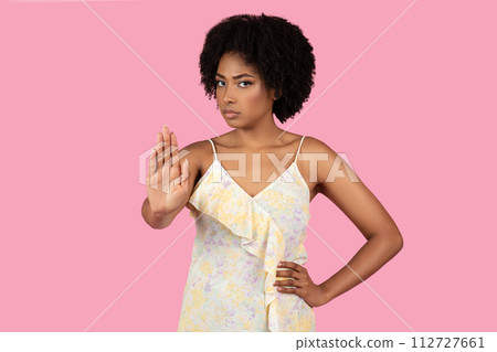 Assertive African-American woman with natural hair showing a stop gesture with her hand Assertive African-American woman with natural hair showing a stop gesture with her hand 112727661