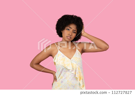 Confused African-American woman scratching her head, with a puzzled expression Confused African-American woman scratching her head, with a puzzled expression 112727827