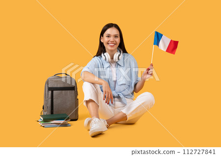 Joyful student lady with French flag, symbolizing global education and cultural exchange 112727841