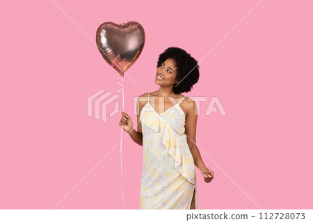 Content African American woman with curly hair, holding a heart-shaped balloon 112728073