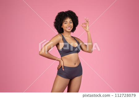 Happy black woman in underwear attire showing OK sign Happy black woman in underwear attire showing OK sign 112728079
