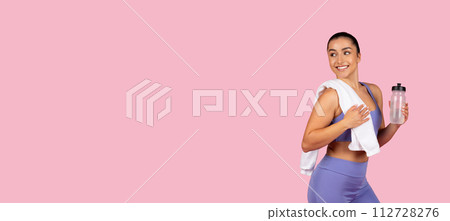 Smiling fit woman with towel and water bottle on pink, panorama, copy space 112728276