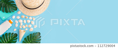 Banner for a summer vacation with shells, palm leaves and a straw hat. Blue background with copy space. Place for text. Banner for a summer vacation with shells, palm leaves and a straw hat. Blue background with copy space. Place for text. 112729004