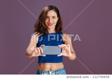 Portrait of slim fit woman filming or taking photos on smartphone Portrait of slim fit woman filming or taking photos on smartphone 112730939