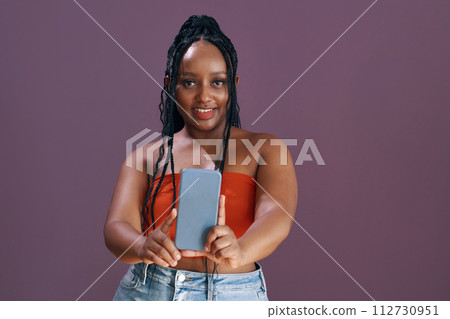 Smiling dressed Black young woman taking selfie for her blog 112730951
