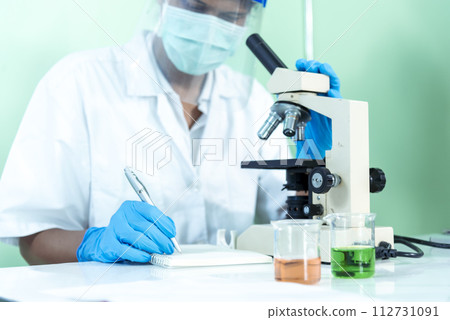 Scientist man look into Microscope research in science laboratory. Asian scientist looking equipment laboratory chemistry labs. Covid-19 coronavirus biochemistry research experiment vaccine concept 112731091