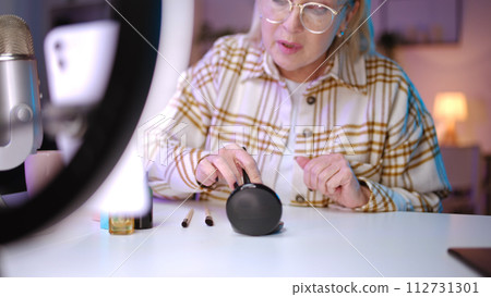 A woman makeup artist is conducting a live stream, revealing secrets for applying powder 112731301
