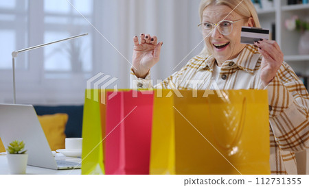 A senior woman is receiving goods instantly after online shopping, thanks to express delivery A senior woman is receiving goods instantly after online shopping, thanks to express delivery 112731355
