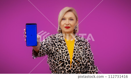A senior woman is showing a smartphone with a pre-keyed screen ready for your advertisement 112731416
