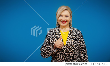 A happy senior woman is showing a thumbs-up and smiling, success, liking something 112731419