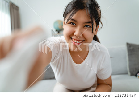 A woman is wiping cleaning the camera lens or screen monitor with paper towel 112731457