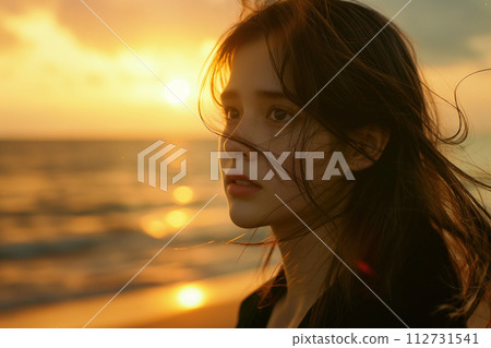 A woman looking at the sea at sunset 112731541