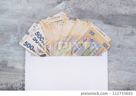 Ukrainian hryvnia in a white envelope on a stone background. Copy of space. 500 hryvnias. Concept of payment or corruption 112733683