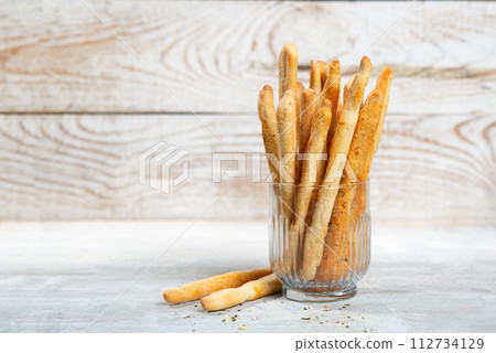 Grissini with herbs on a gray concrete background 112734129