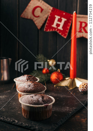 chocolate muffins with powdered sugar on top on a black background. Christmas decoration . Still life close up. Food photo chocolate muffins with powdered sugar on top on a black background. Christmas decoration . Still life close up. Food photo 112734159