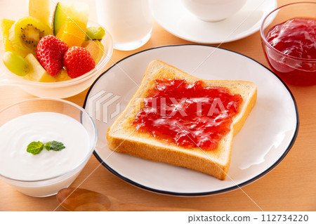 Apply strawberry jam to toast 112734220