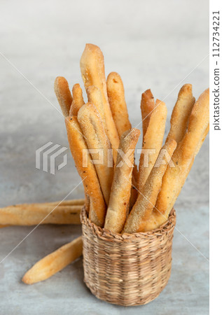 Grissini with herbs on a gray concrete background 112734221