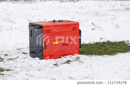 Portable electric generator running in the cold winter.Energy genocide. Power outage as a result of missile strikes by Russia on energy facilities of Ukraine. Small business use gasoline generators. 112734276