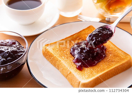 將藍莓果醬塗在吐司上 112734304