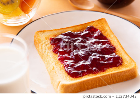 將藍莓果醬塗在吐司上 112734342