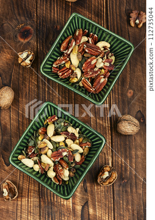 Assortment of nuts on wooden backgrounds. 112735044