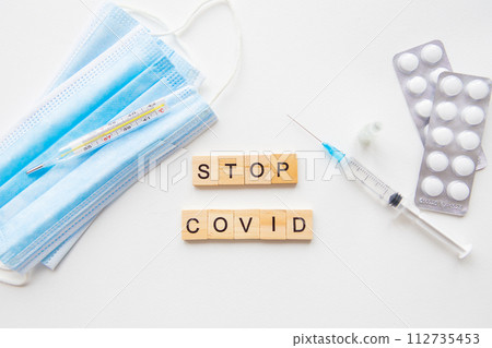 Stop coronavirus inscription. Preparing for vaccination against covid. Syringe, vaccine, pills, medical mask. A new strain of the virus. 112735453
