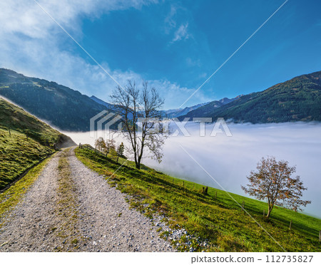 Peaceful misty autumn morning mountain view from hiking path from Dorfgastein to Paarseen lakes, Land Salzburg, Austria. Peaceful misty autumn morning mountain view from hiking path from Dorfgastein to Paarseen lakes, Land Salzburg, Austria. 112735827