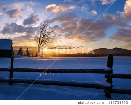 Small and quiet alpine village outskirts and winter sunrise snowy mountains around, Voronenko, Carpathian, Ukraine. 112735850