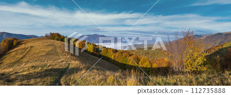 Foggy early morning autumn mountains scene. Peaceful picturesque traveling, seasonal, nature and countryside beauty concept scene. Carpathian Mountains, Ukraine. Foggy early morning autumn mountains scene. Peaceful picturesque traveling, seasonal, nature and countryside beauty concept scene. Carpathian Mountains, Ukraine. 112735888