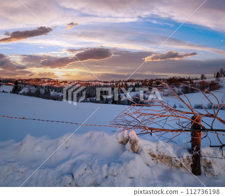 Small and quiet alpine village and winter sunrise snowy mountains around, Voronenko, Carpathian, Ukraine. 112736198