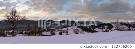 Small alpine village and winter snowy mountains in first sunrise sunlight around, Voronenko, Carpathian, Ukraine. Trace on freshly trodden path through snow drifts. Small alpine village and winter snowy mountains in first sunrise sunlight around, Voronenko, Carpathian, Ukraine. Trace on freshly trodden path through snow drifts. 112736200