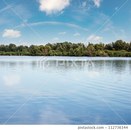 Summer hazy day on picturesque lake 112736344